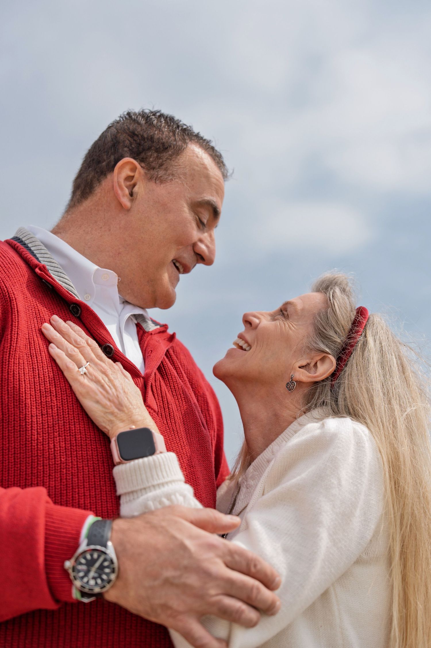 A couple in red and white sweaters share romantic moments together in a series of intimate outdoor portraits.