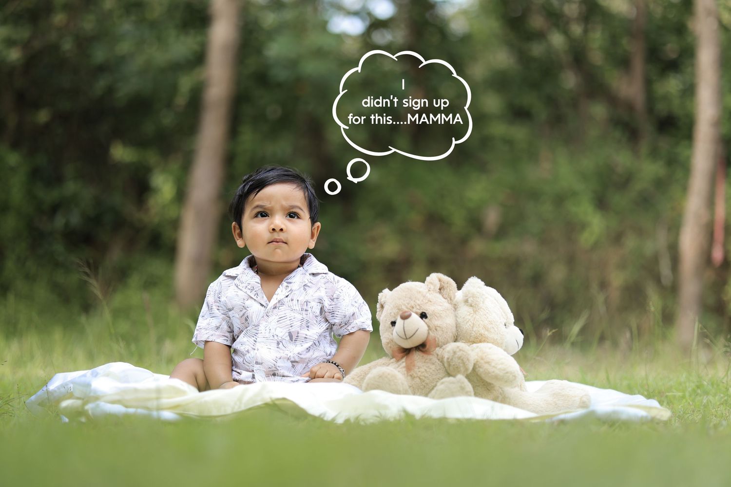 Baby sitting outdoors with a teddy bear during a children’s photoshoot