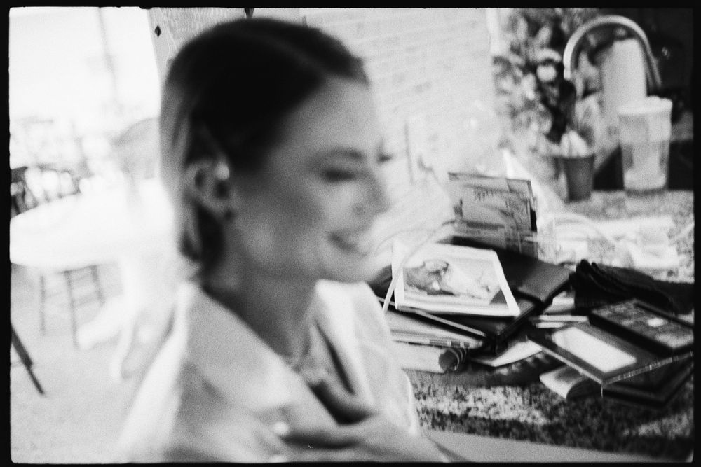 Soft focus black and white portrait of bride at vanity during wedding preparations.