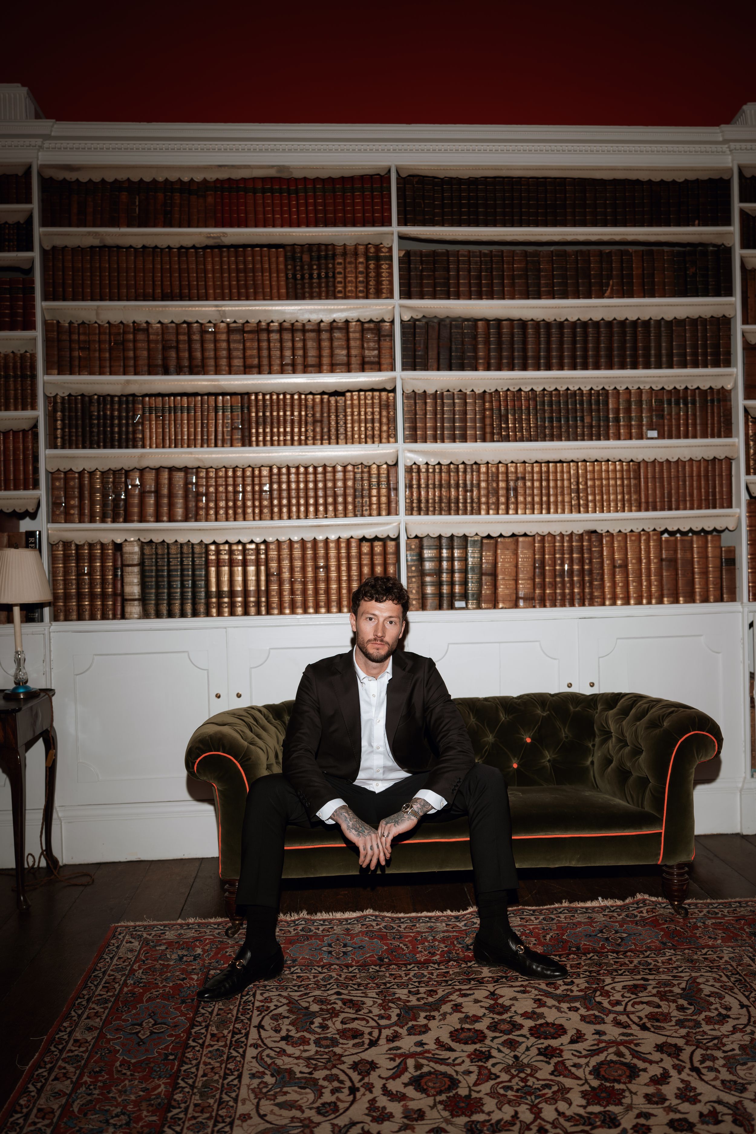 A series of photos showing someone sitting and lounging on a dark leather couch against a wall of bookshelves.