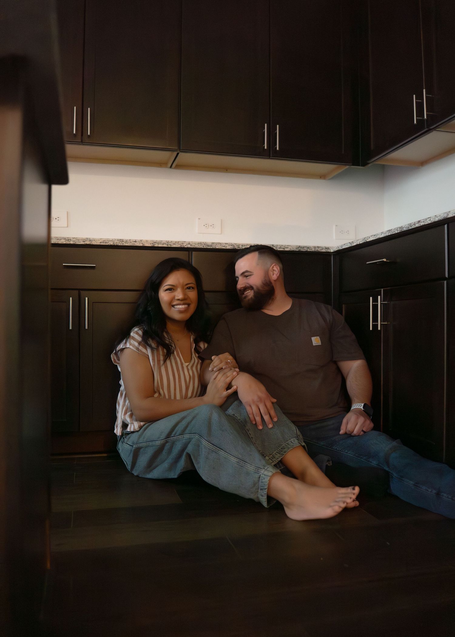 The Emerson Family of five posing in their empty new home, smiling and exploring their new space together