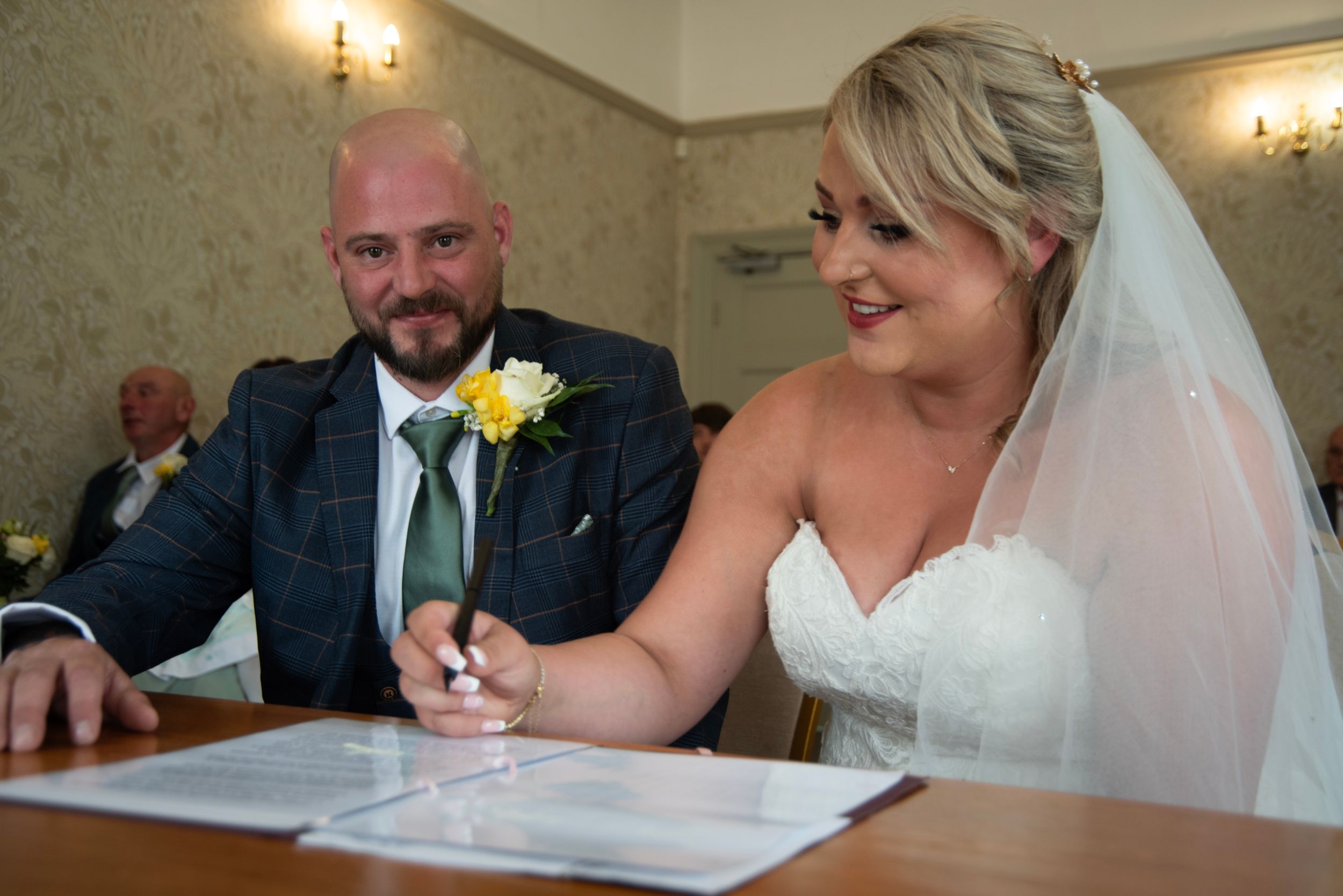 Candid moments of a wedding couple signing documents during their marriage ceremony.
