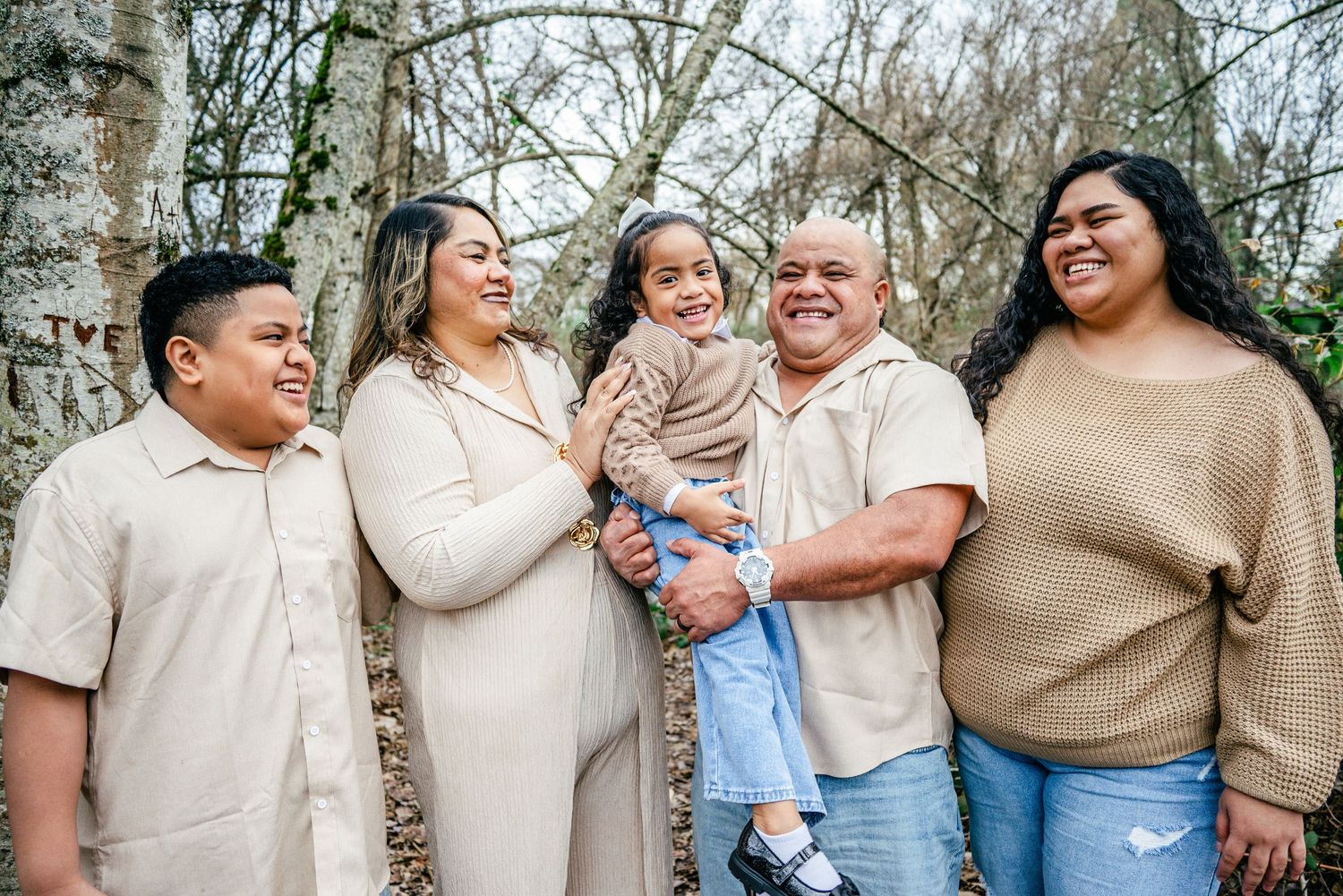 Candid family photo showing parents and children laughing together during a winter session in Puyallup