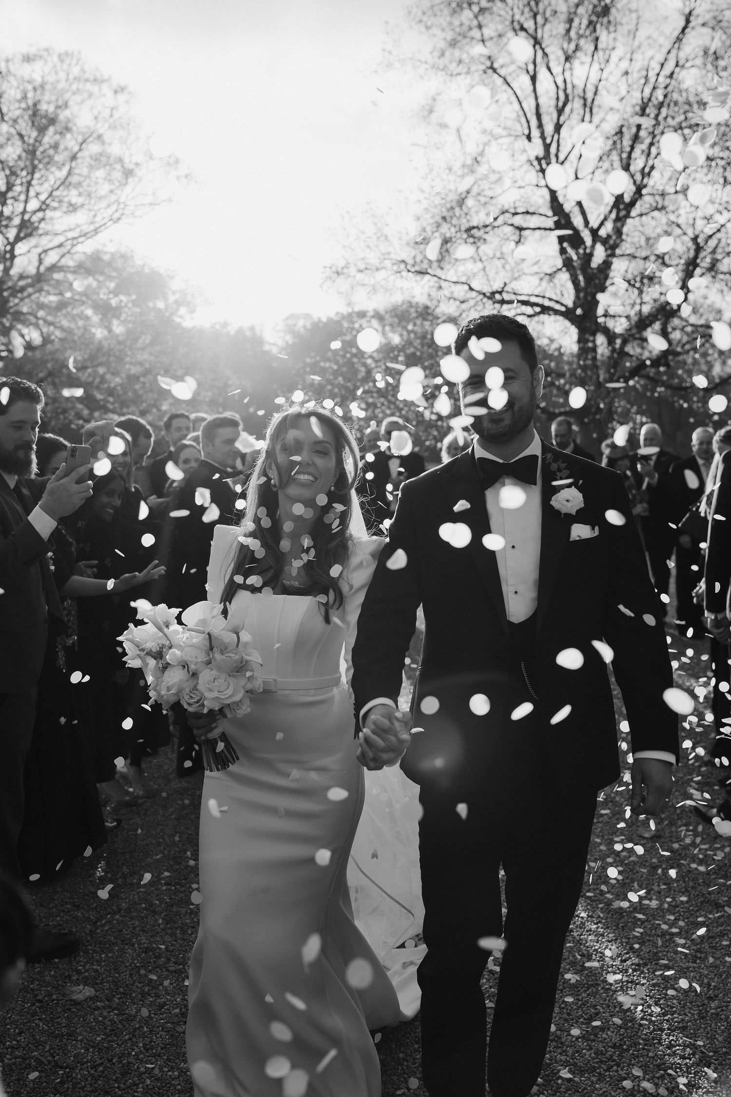 wedding guests throwing confetti over the bride and groom at Iscoyd park