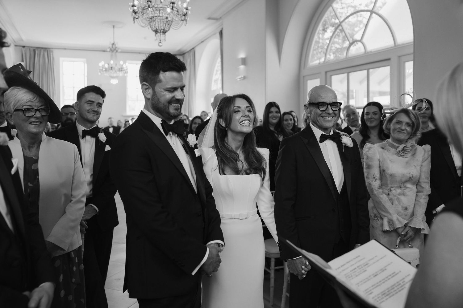 bride groom and parents at the alter, smiling as the couple seeing each ohter for the first time during the ceremony at Iscoyd park