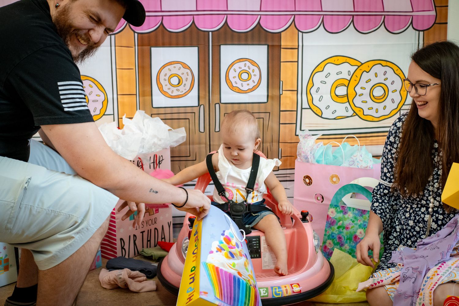 Family plays together in colorful donut shop themed playroom setting.