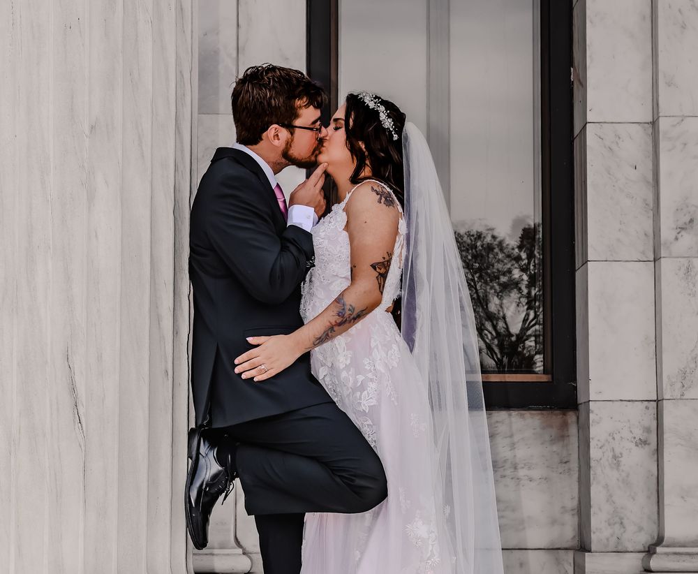 A romantic wedding photoshoot sequence showing a couple kissing against a marble column backdrop.