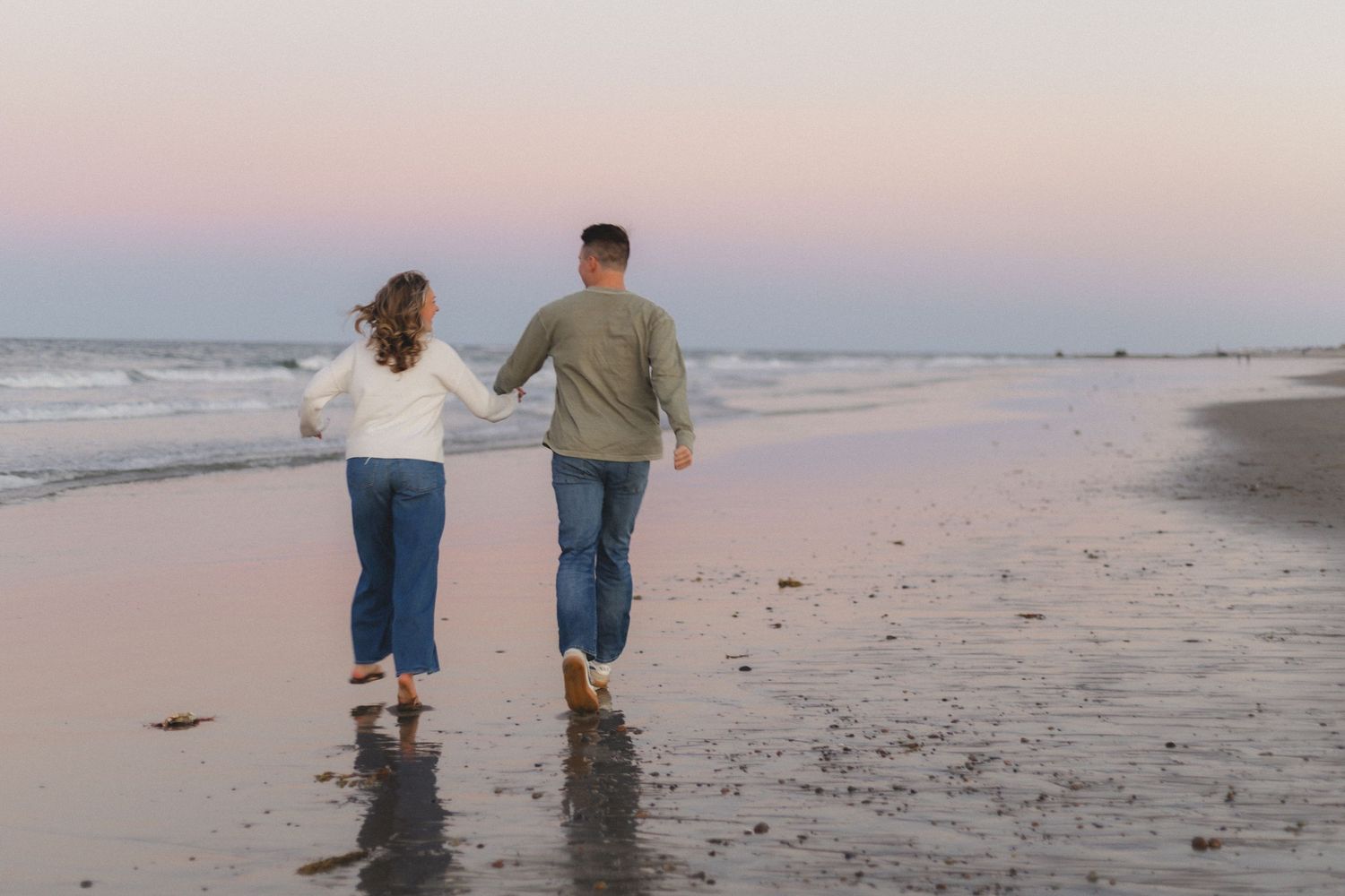 A romantic engagement photo session in a golden marsh field during sunset.