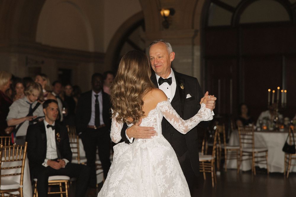 Couples dancing together at an elegant evening wedding reception in a grand ballroom.