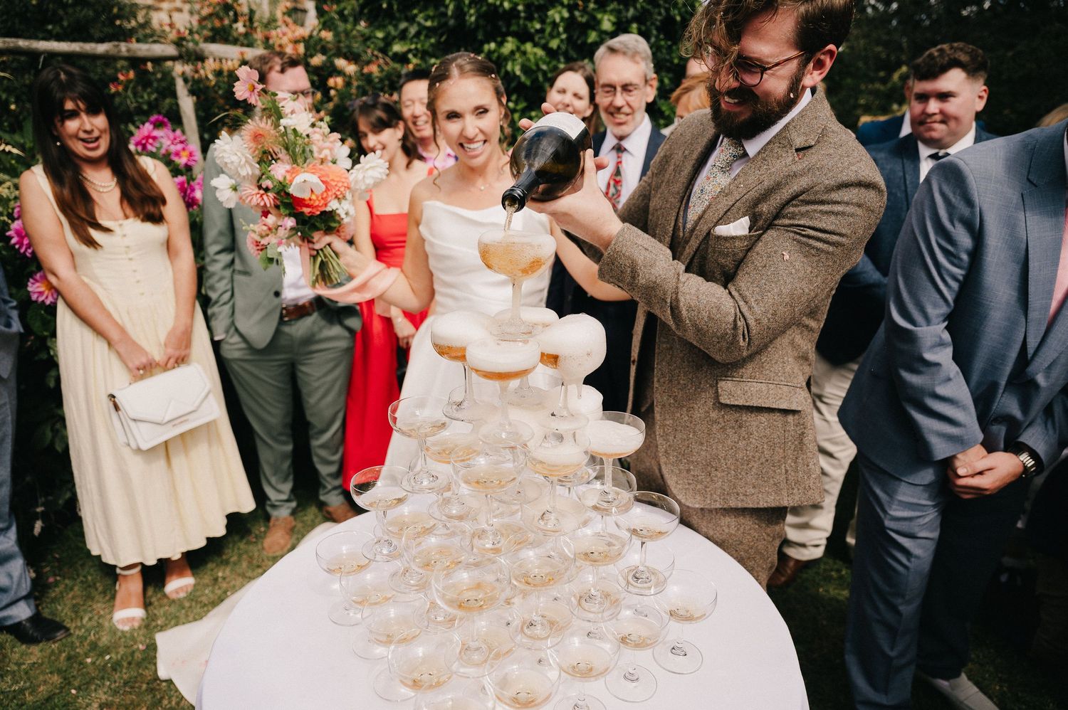 Outdoor wedding ceremony with guests seated on white chairs overlooking a natural landscape.