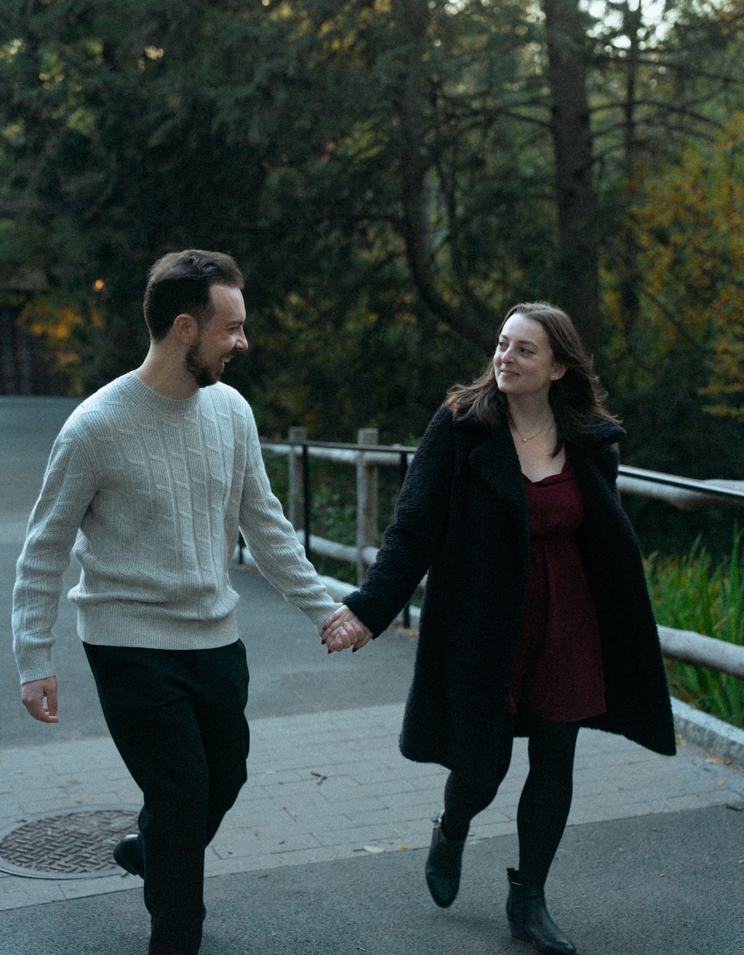 Couple walking together on outdoor path during autumn sunset.