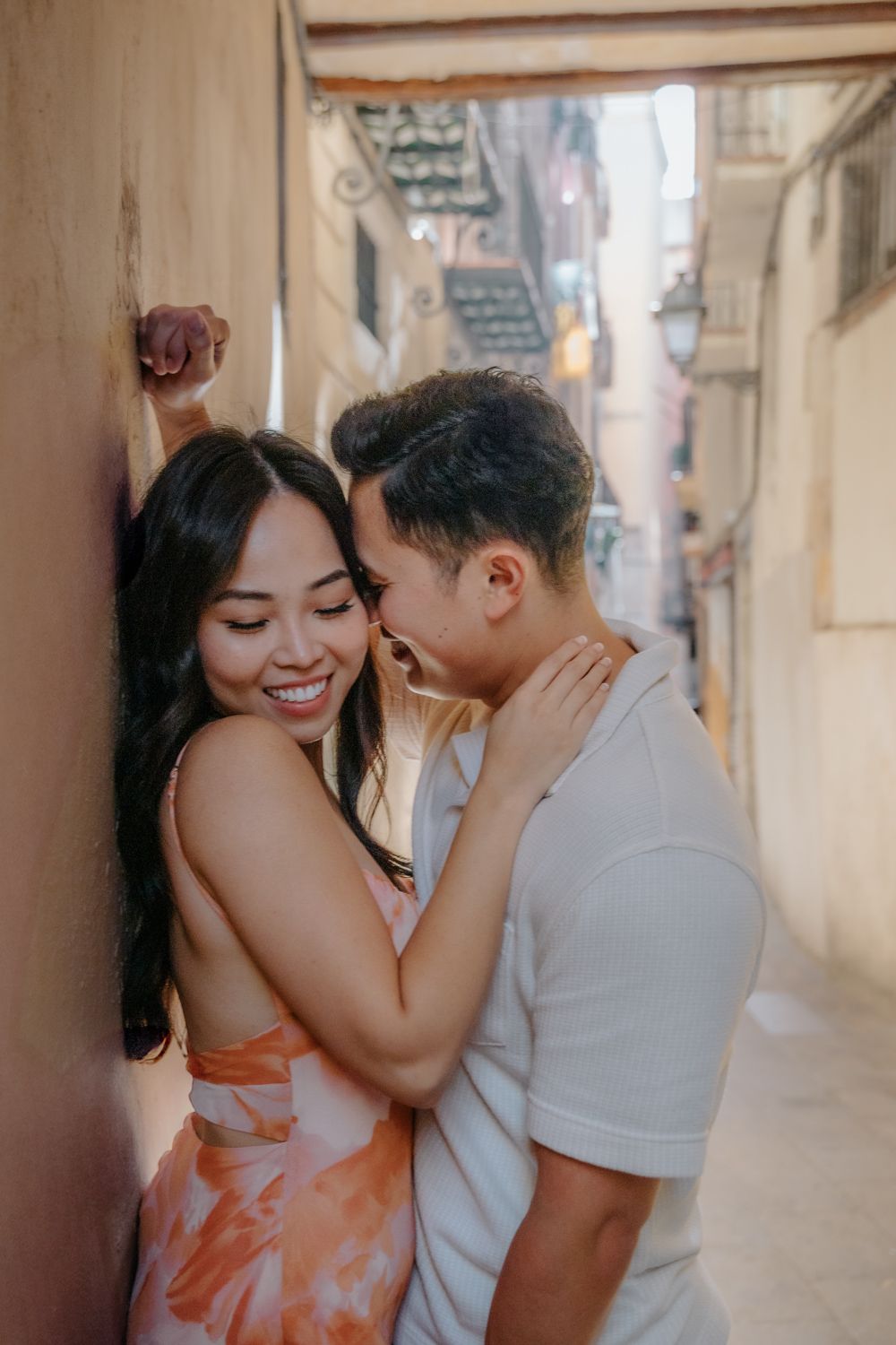 Romantic kiss under a stone archway in the Gothic Quarter.