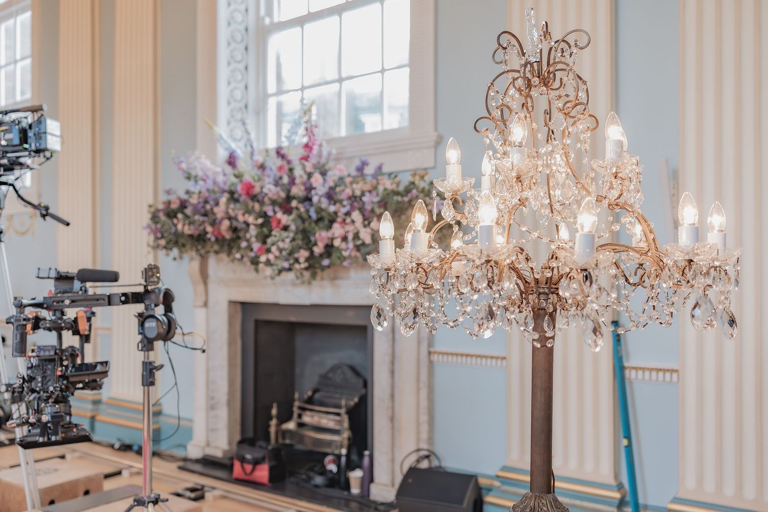 Behind the scenes of a Bridgerton Netflix filming setup at Newark Town Hall, showing the ballroom fireplace area full equipment set up.