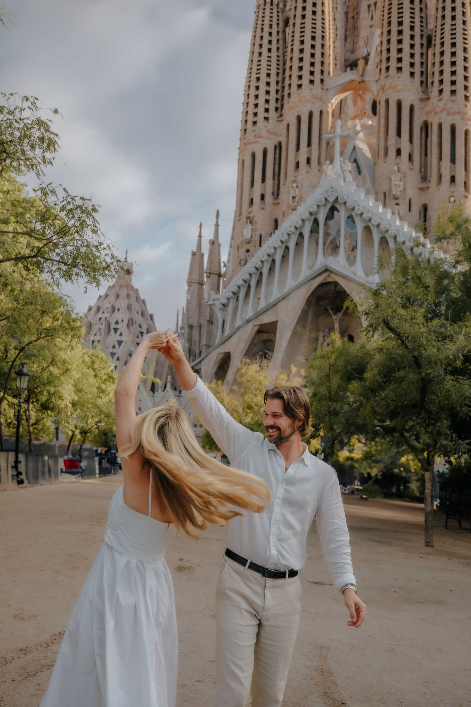 Couple walking slowly around the Sagrada Família park.