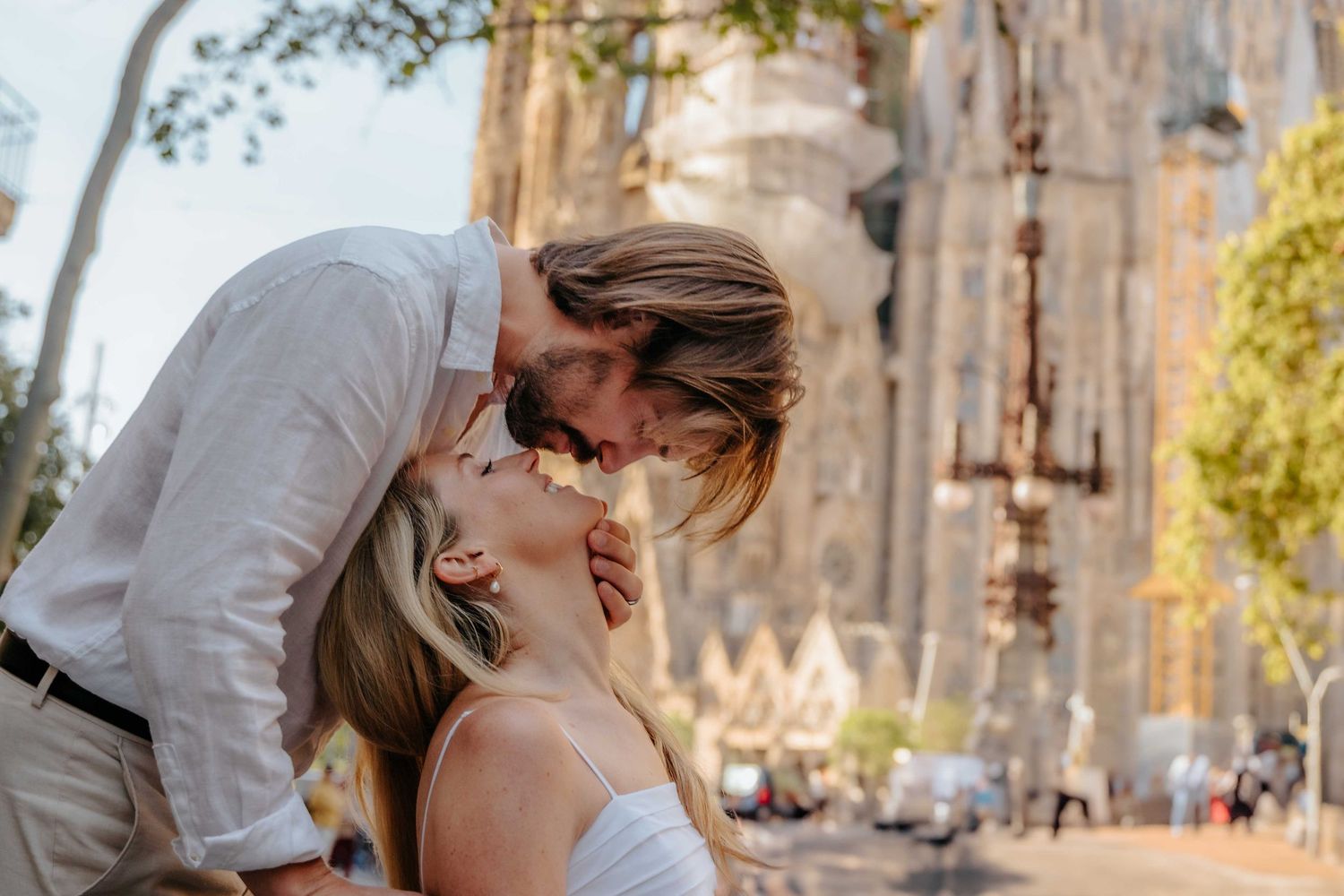 Wide shot of couple framed by the Nativity Facade of Sagrada Família.