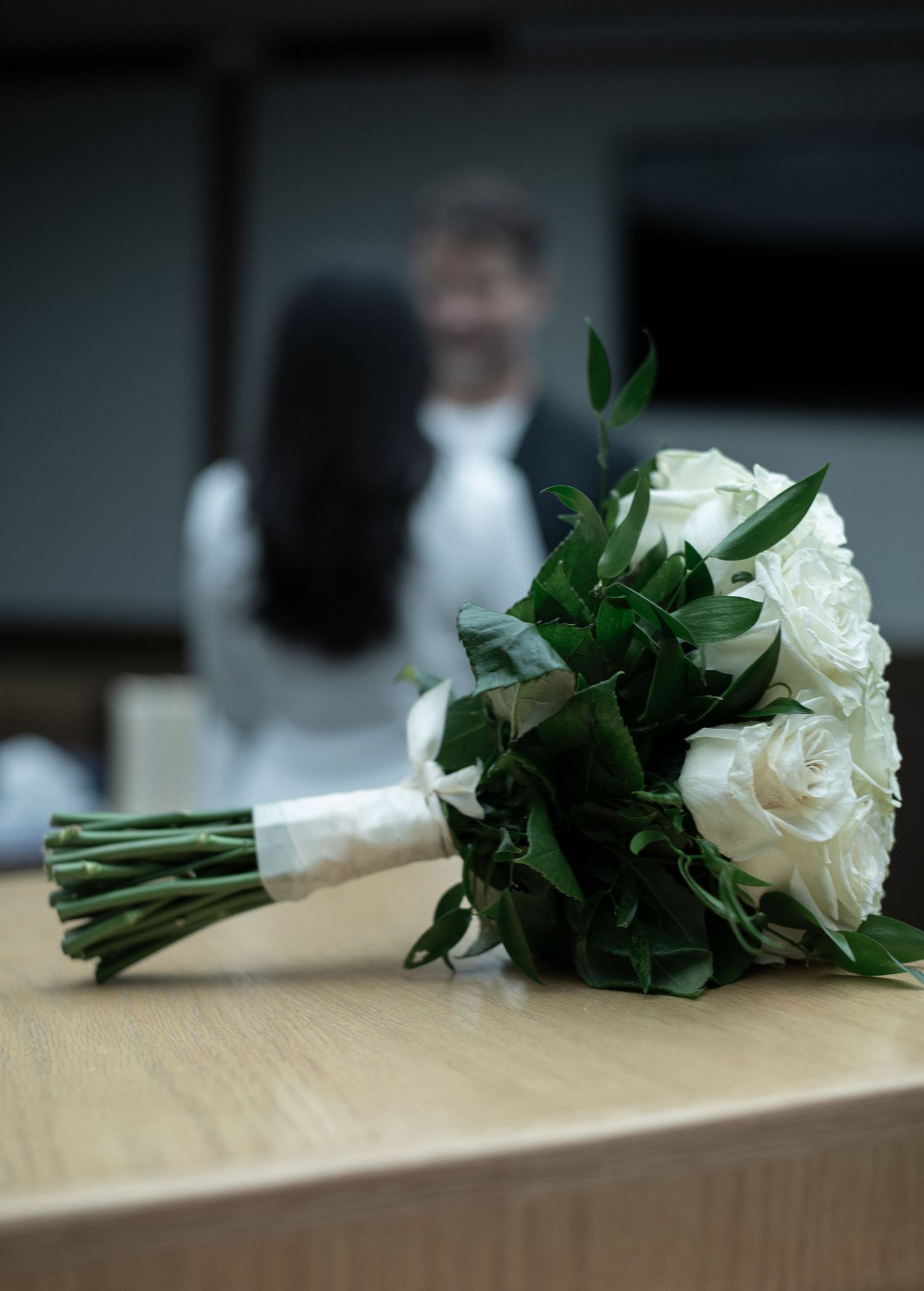 A bride's white rose wedding bouquet during their minimal elegant intimate elopement at the Blaine County Courthouse in Hailey, Idaho.