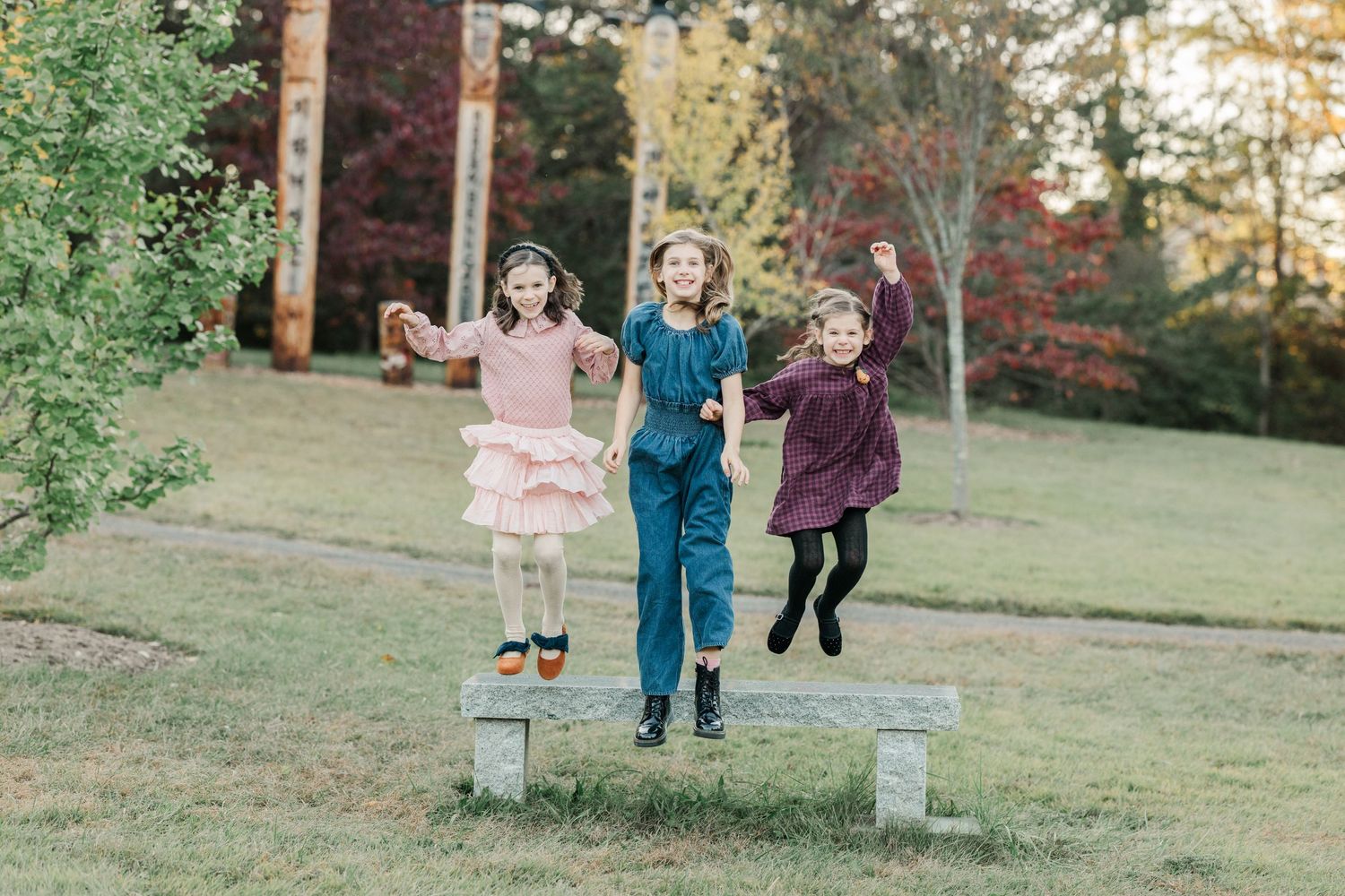 Children play and run together in a grassy outdoor setting during autumn.