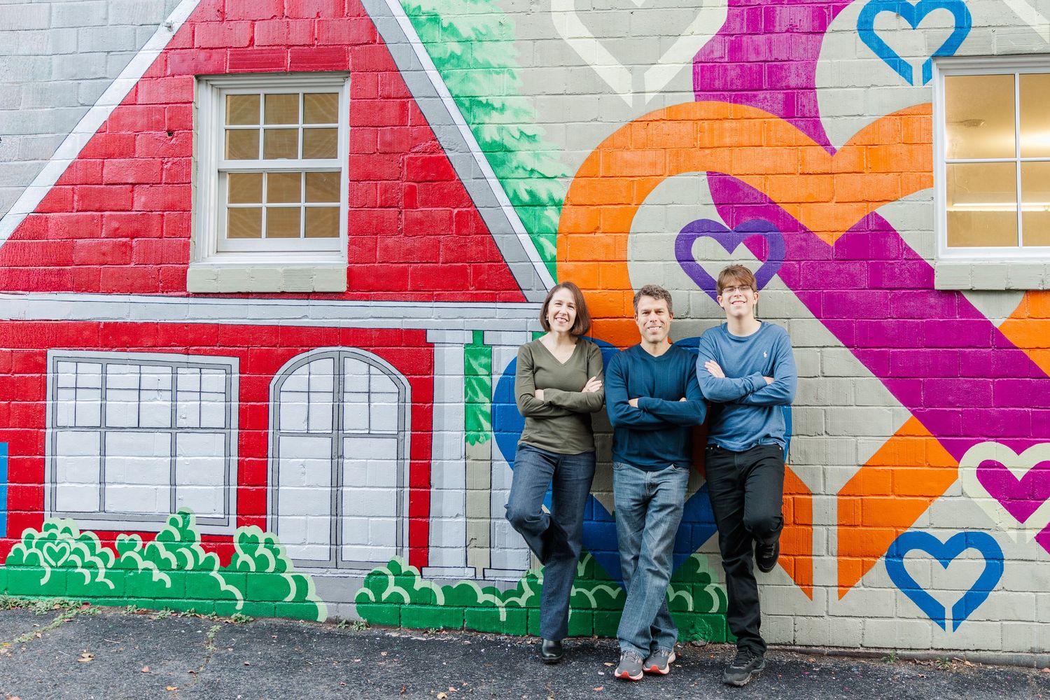 Colorful heart mural painted on brick wall with bright pink, orange, and green geometric shapes and patterns.