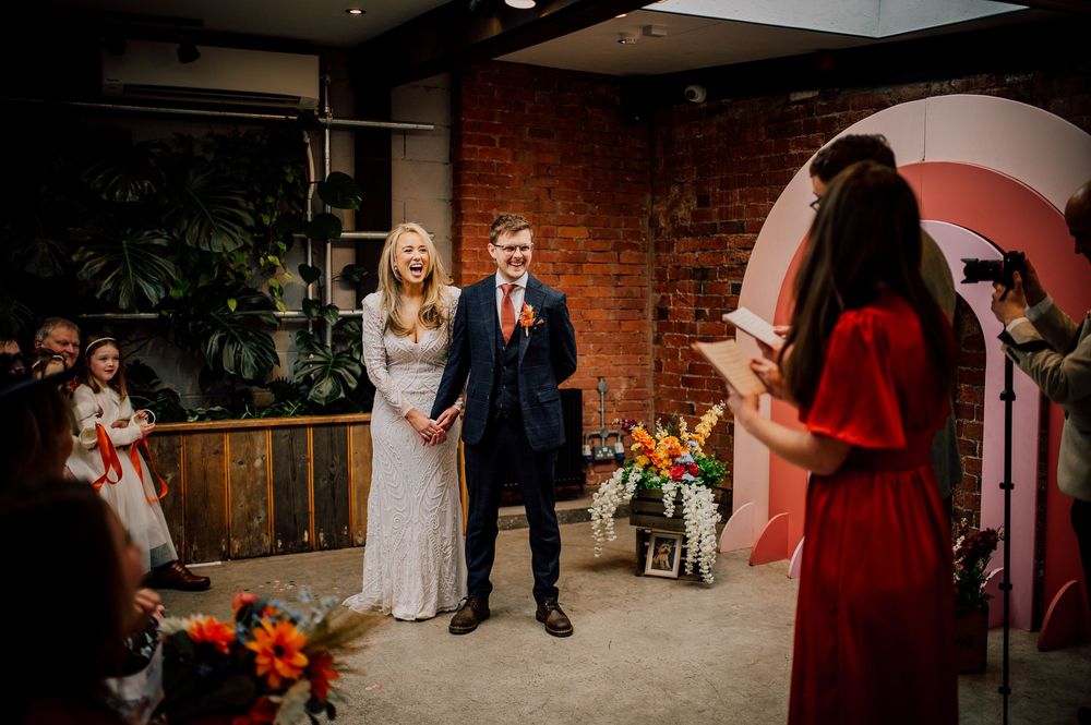 A romantic wedding celebration in a rustic brick venue with warm lighting and elegant decor.