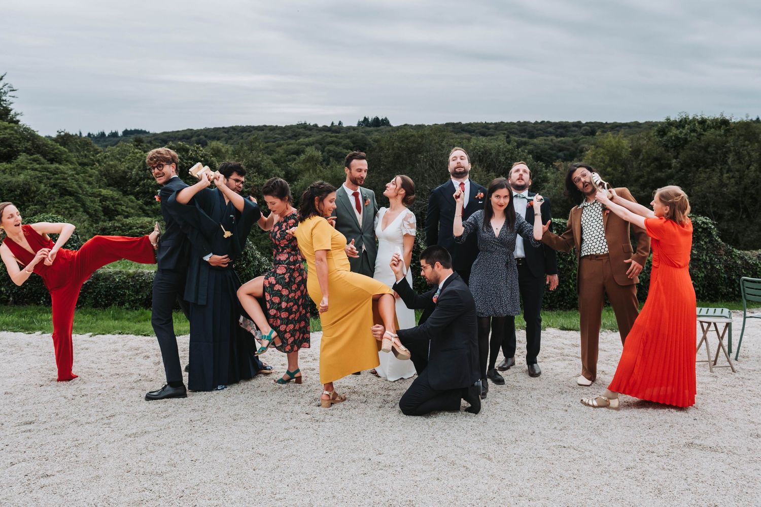 Groupe de mariés et témoins posant avec caractère face à un paysage breton, photo de mariage dynamique.