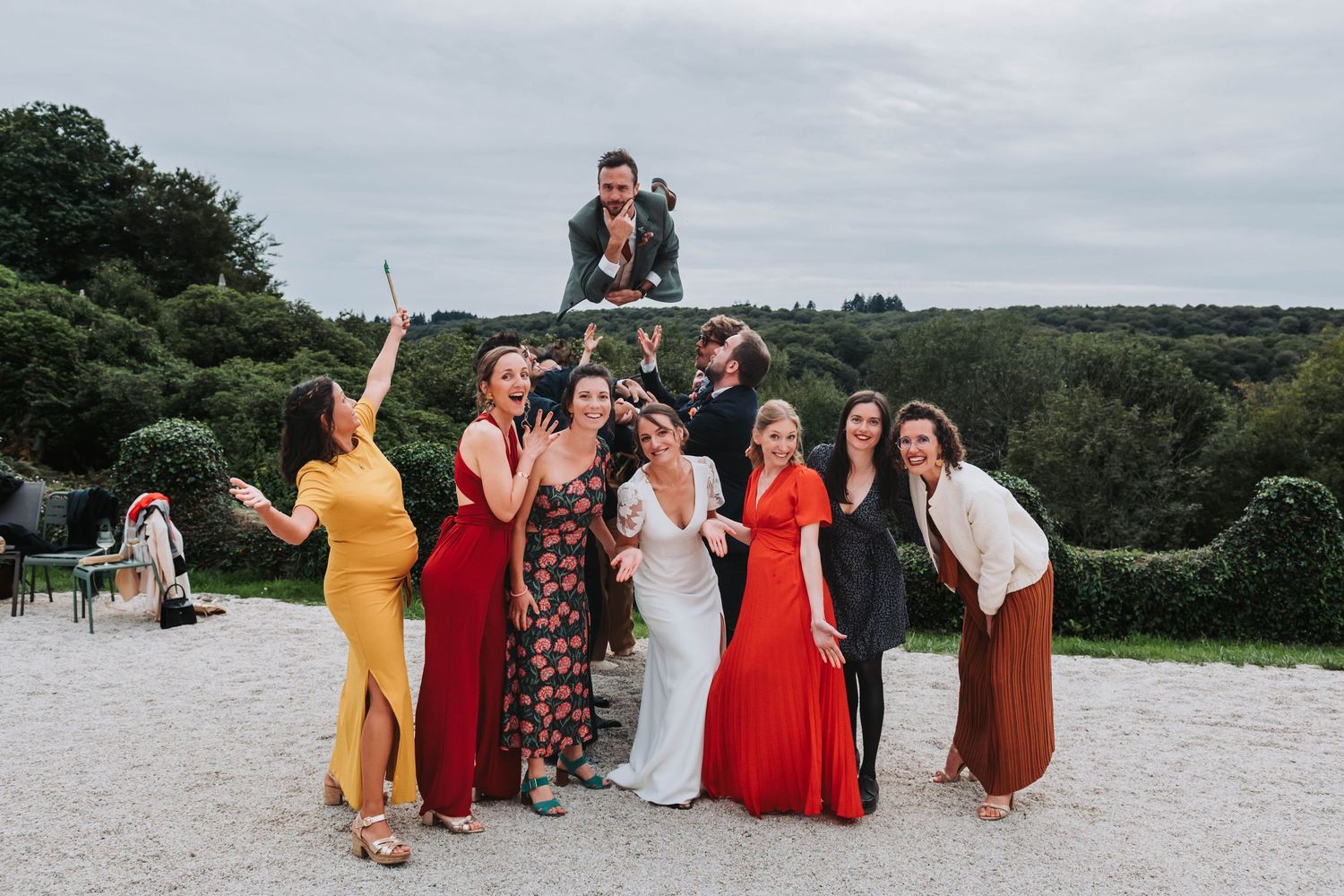 Photo de groupe festive lors d’un mariage en Bretagne, invités élégants posant avec énergie en extérieur.