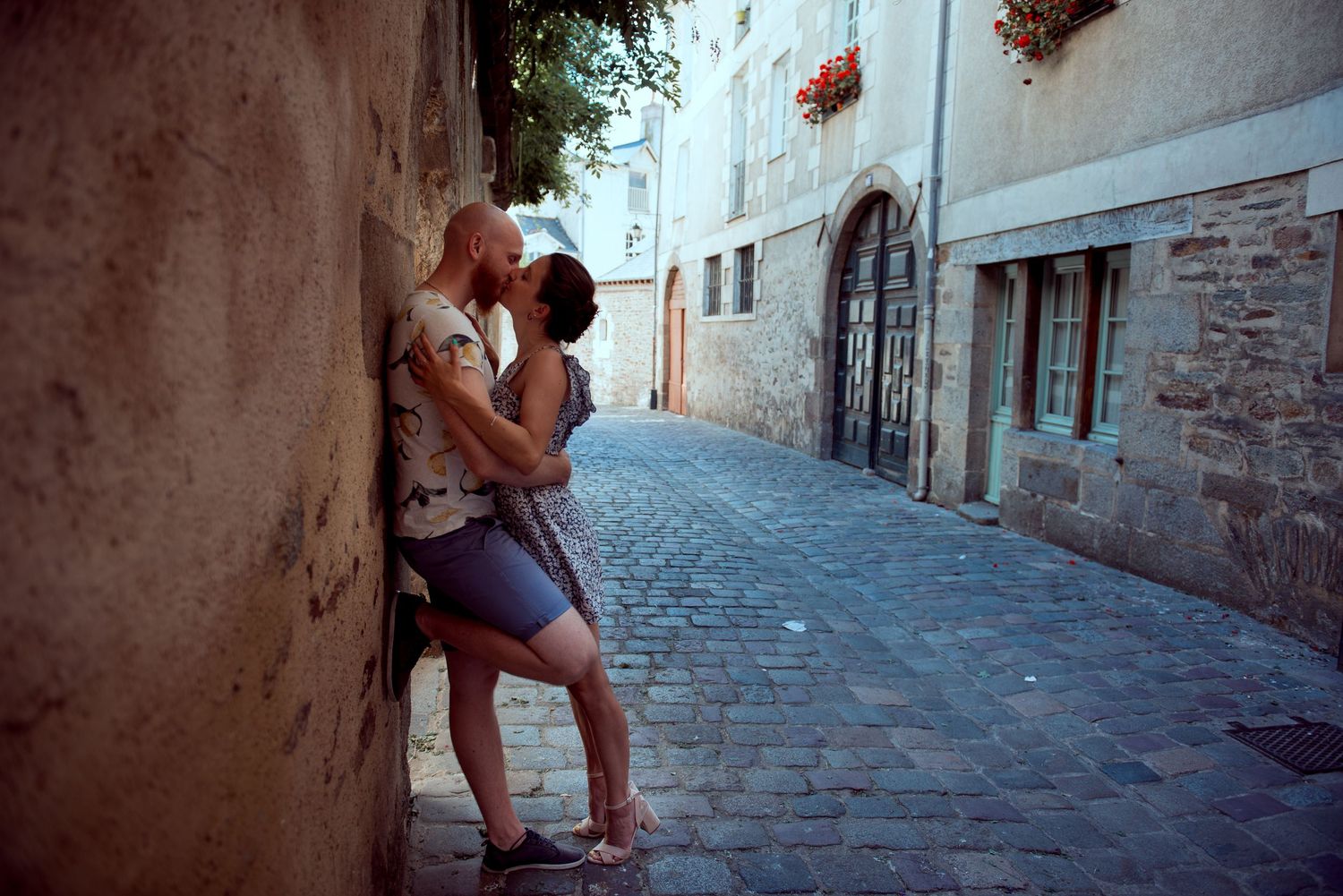 Couple de mariés enlacé dans une ruelle en pierre, séance photo de mariage intime.