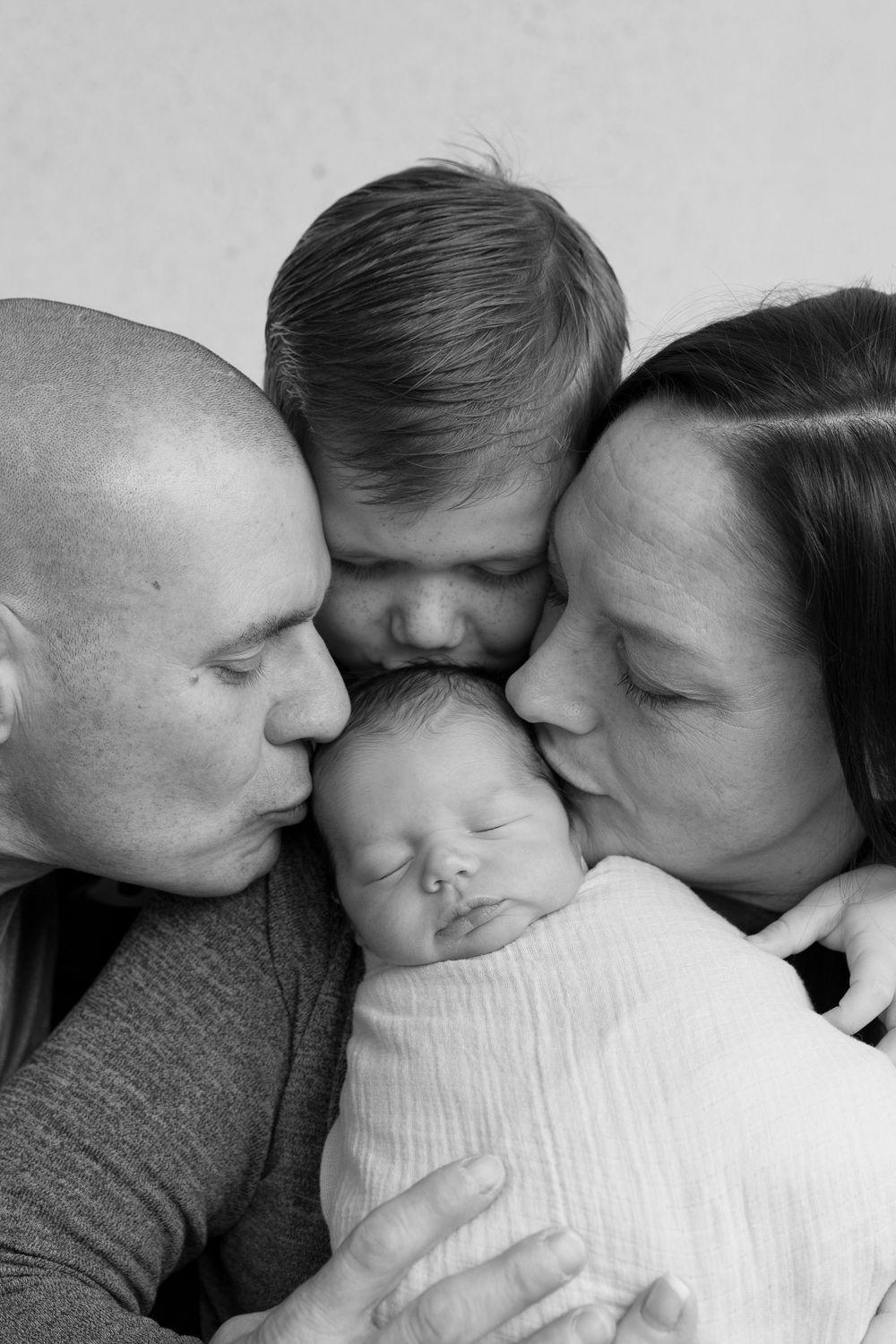 A series of black and white photos showing tender moments of closeness and affection between family members.