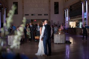 Bride and groom sharing first dance under Jennifer and Justin wedding sign in elegant reception venue.