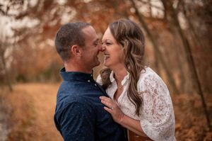 Romantic couple sharing close moment surrounded by warm autumn colors outdoors.