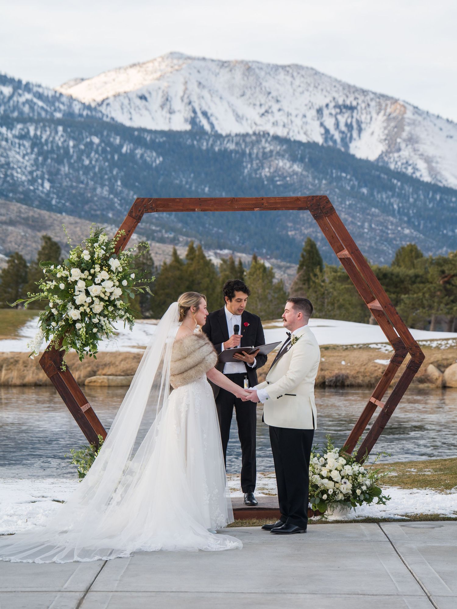 A lakeside wedding ceremony with snowy mountains in the background at Lake Tahoe.