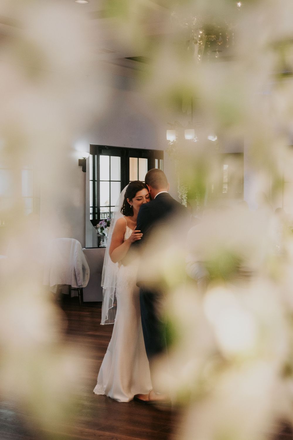 Romantic dance sequence between bride and groom in an elegantly lit indoor venue.
