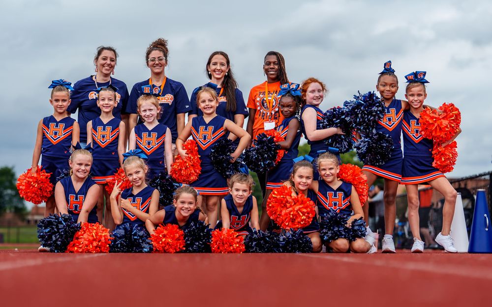 Youth cheerleading squad posing together in matching uniforms in Hershey PA by SportsFox Photography.