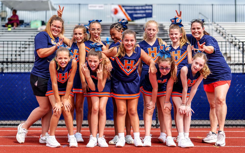 Youth cheerleading squad posing together in matching uniforms in Hershey PA by SportsFox Photography.