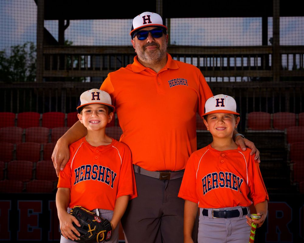 Little league all-stars baseball players and coach at home plate with dramatic lighting, Hershey, PA, photographed by SportsFox Photography.