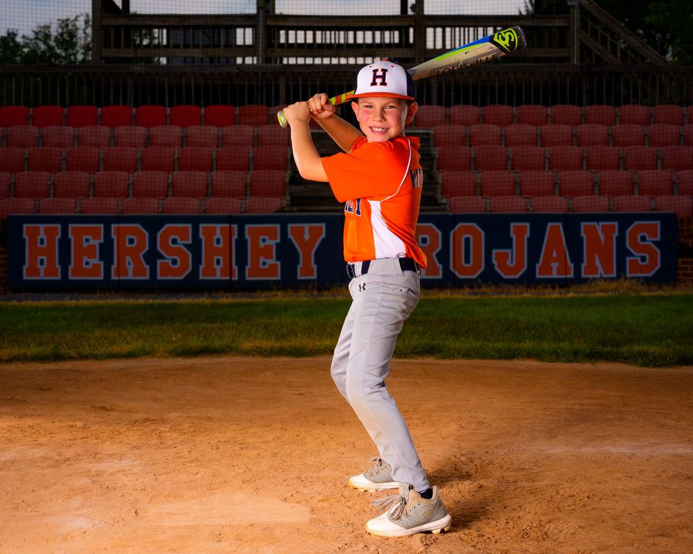 Little League All-Star baseball player posing at home plate with dramatic lighting in Hershey PA, photographed by SportsFox Photography.