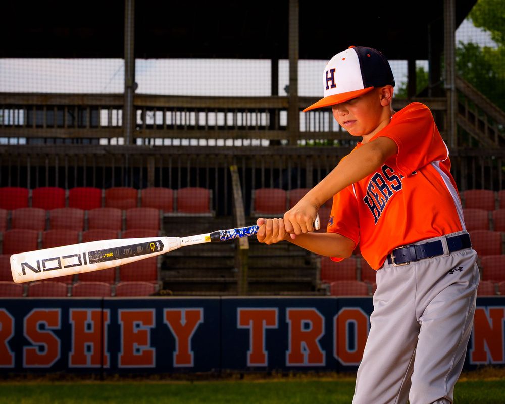 Little League All-Star baseball player posing at home plate with dramatic lighting in Hershey PA, photographed by SportsFox Photography.