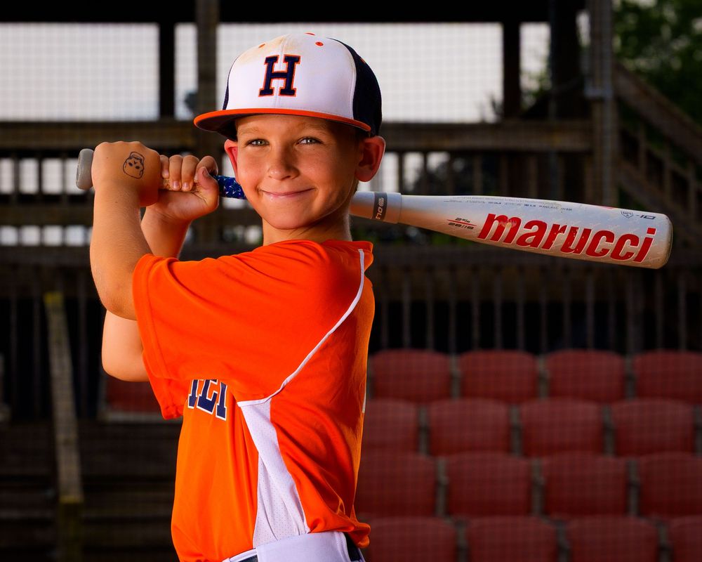 Little League All-Star baseball player posing at home plate with dramatic lighting in Hershey PA, photographed by SportsFox Photography.