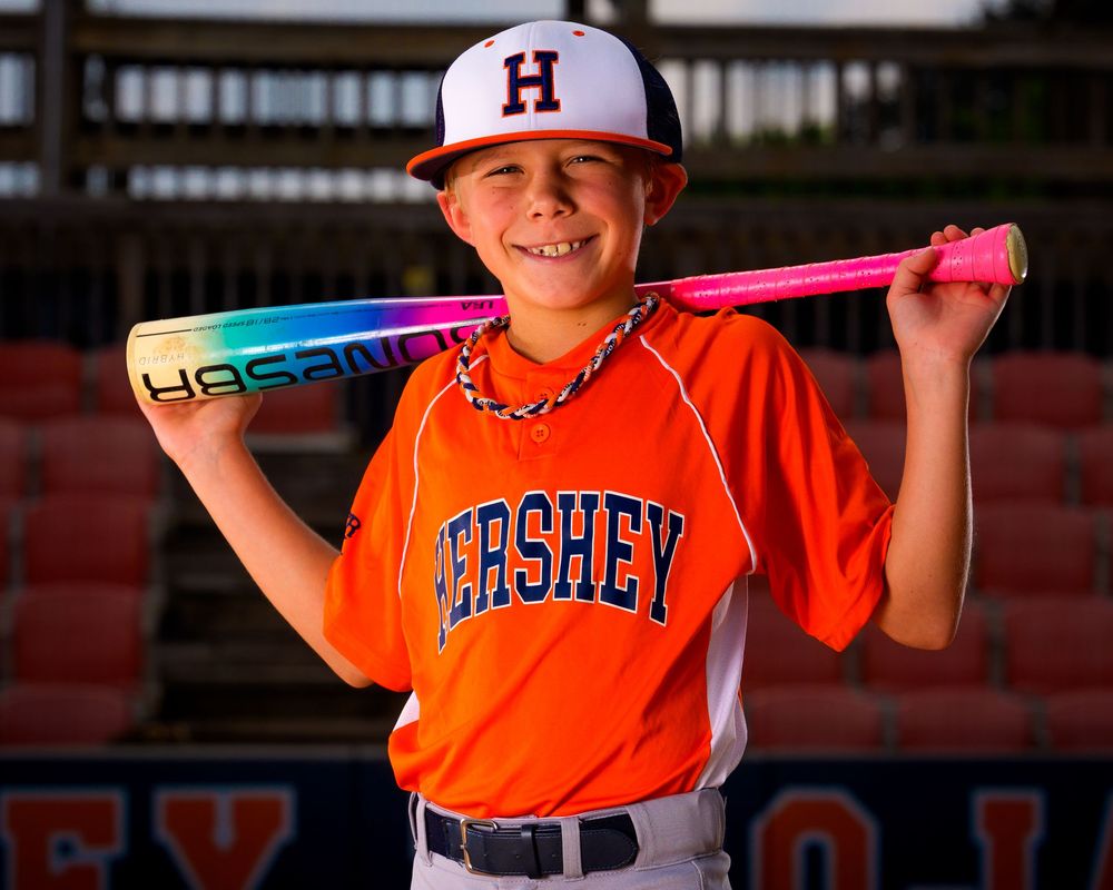 Little League All-Star baseball player posing at home plate with dramatic lighting in Hershey PA, photographed by SportsFox Photography.