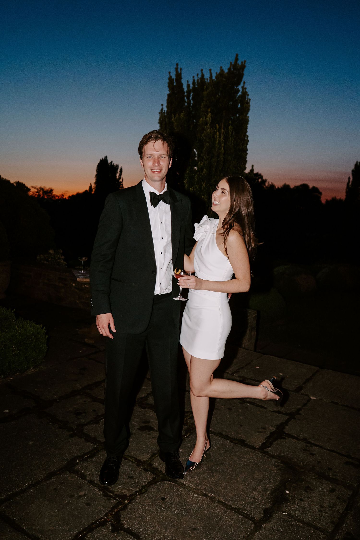 bride smiling at the groom with the last of the sunlight setting on the horizon at dewsall court in herefordshire