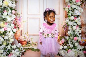 Spring photo session with pink tulle dress against romantic floral arch background.