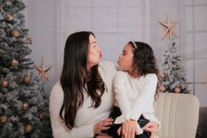 Holiday portraits with Christmas tree and star decorations in elegant white studio setting.