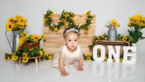 Yellow sunflower backdrop with wooden panels and rustic decor elements.