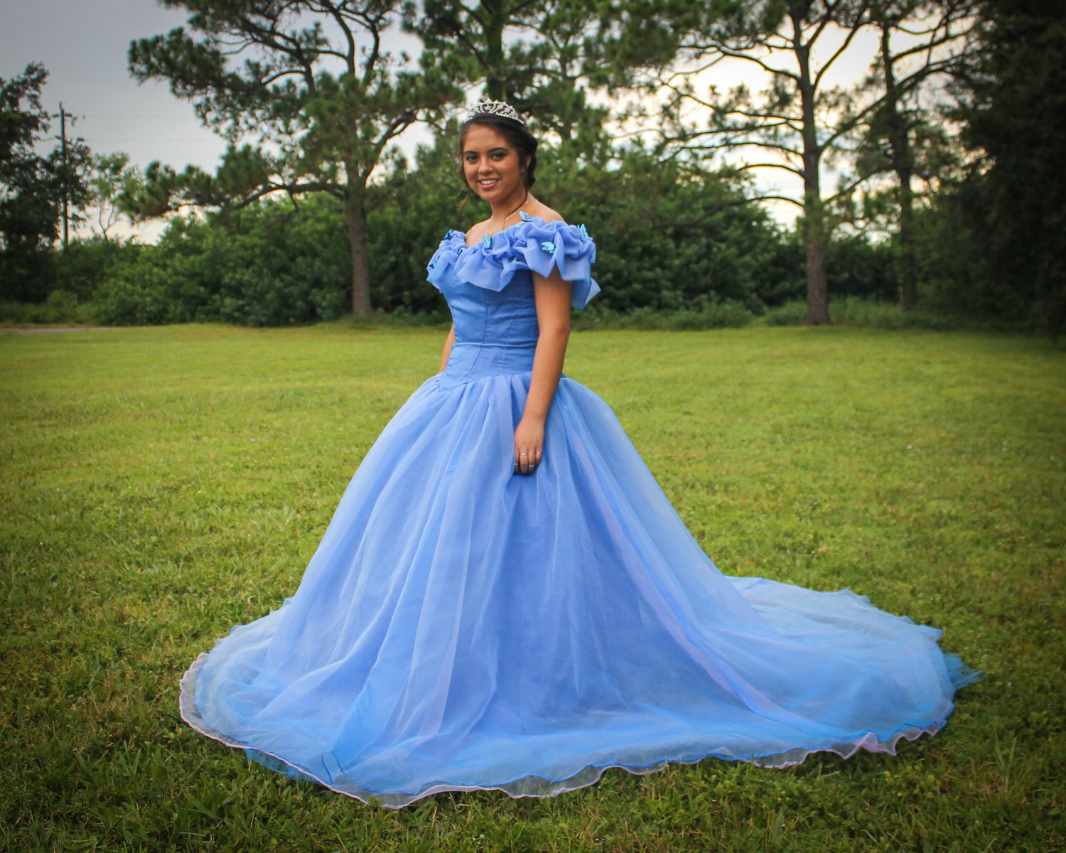 A series of portraits featuring a flowing blue ball gown in an outdoor garden setting at dusk.