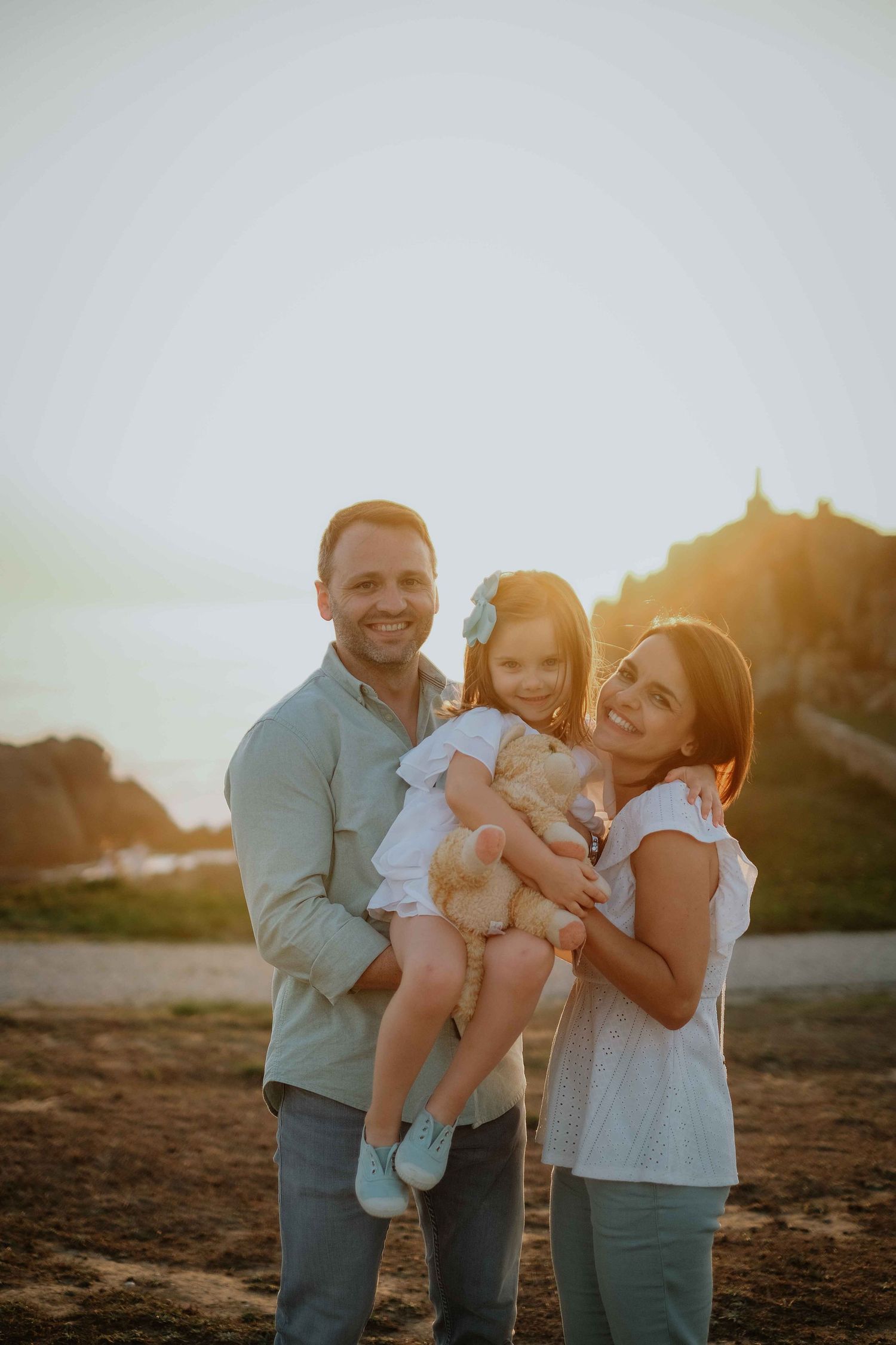 Family shares joyful moments together during golden hour outdoor photography session.