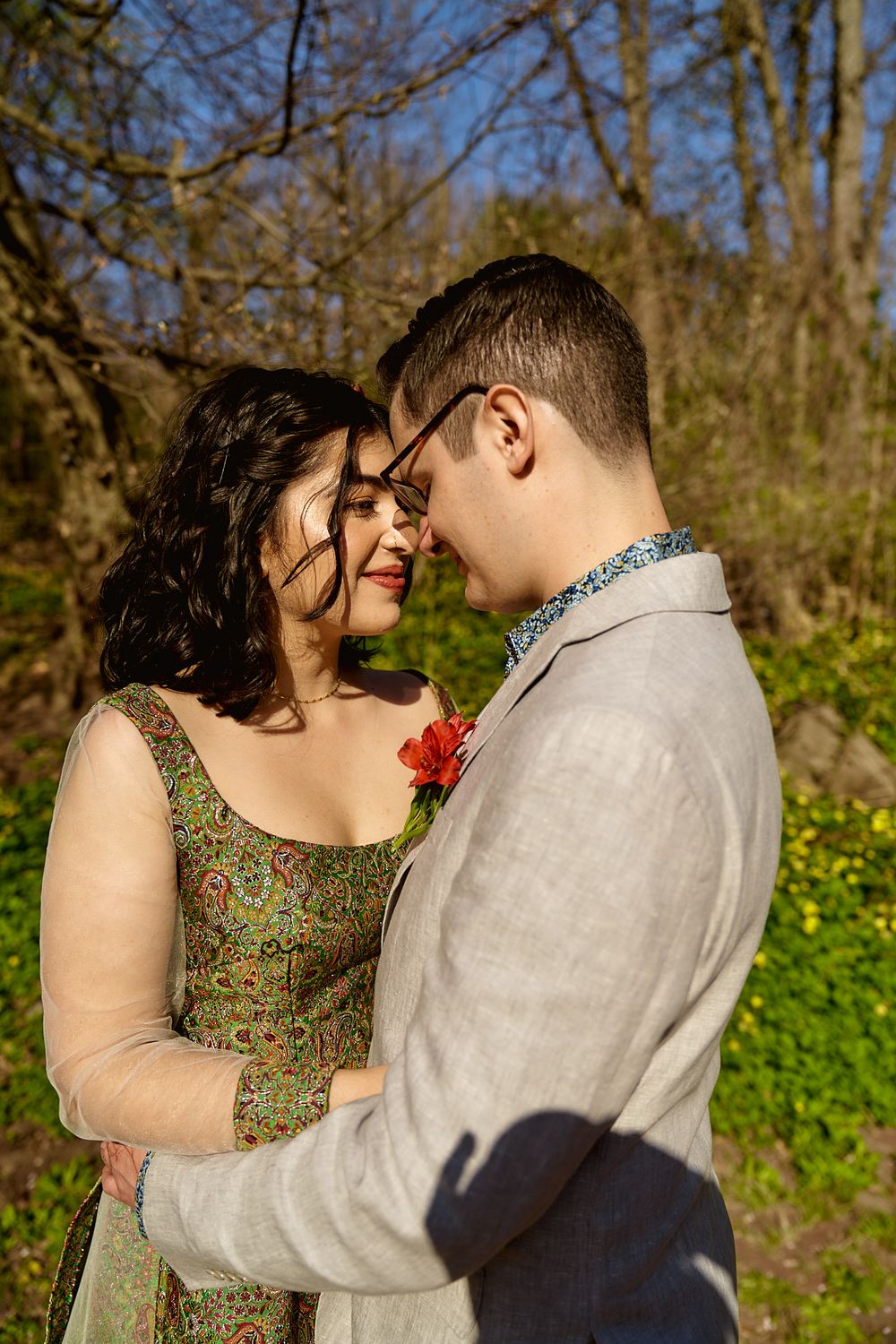An intimate moment between a couple in formal wear standing among yellow spring flowers.