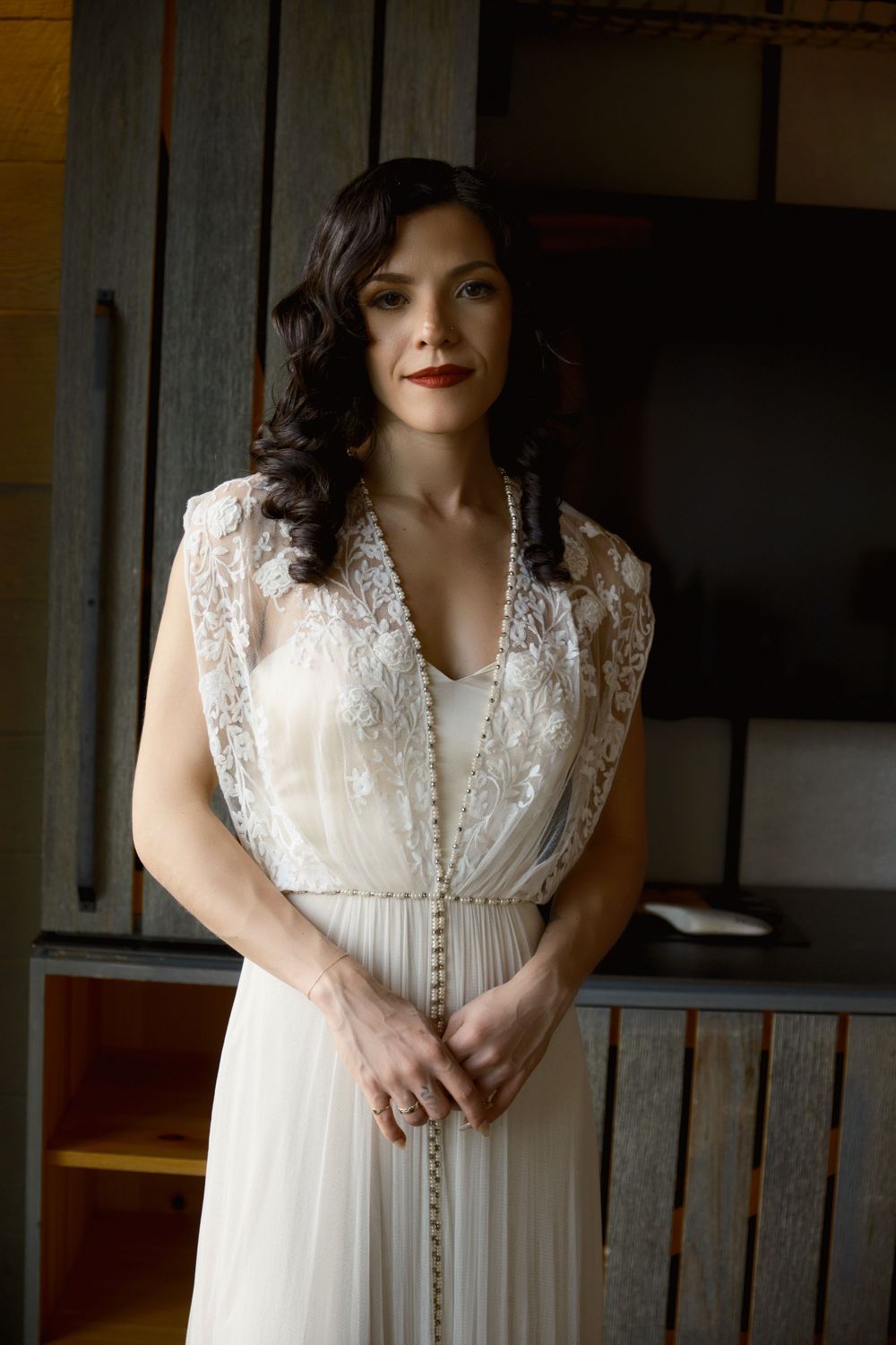 An elegant ivory wedding dress with delicate lace details and flowing fabric photographed indoors at Mayson May
