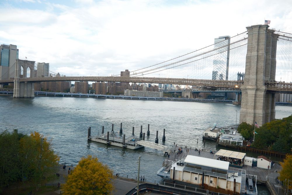 View of the Brooklyn Bridge and East River with autumn foliage in New York City.