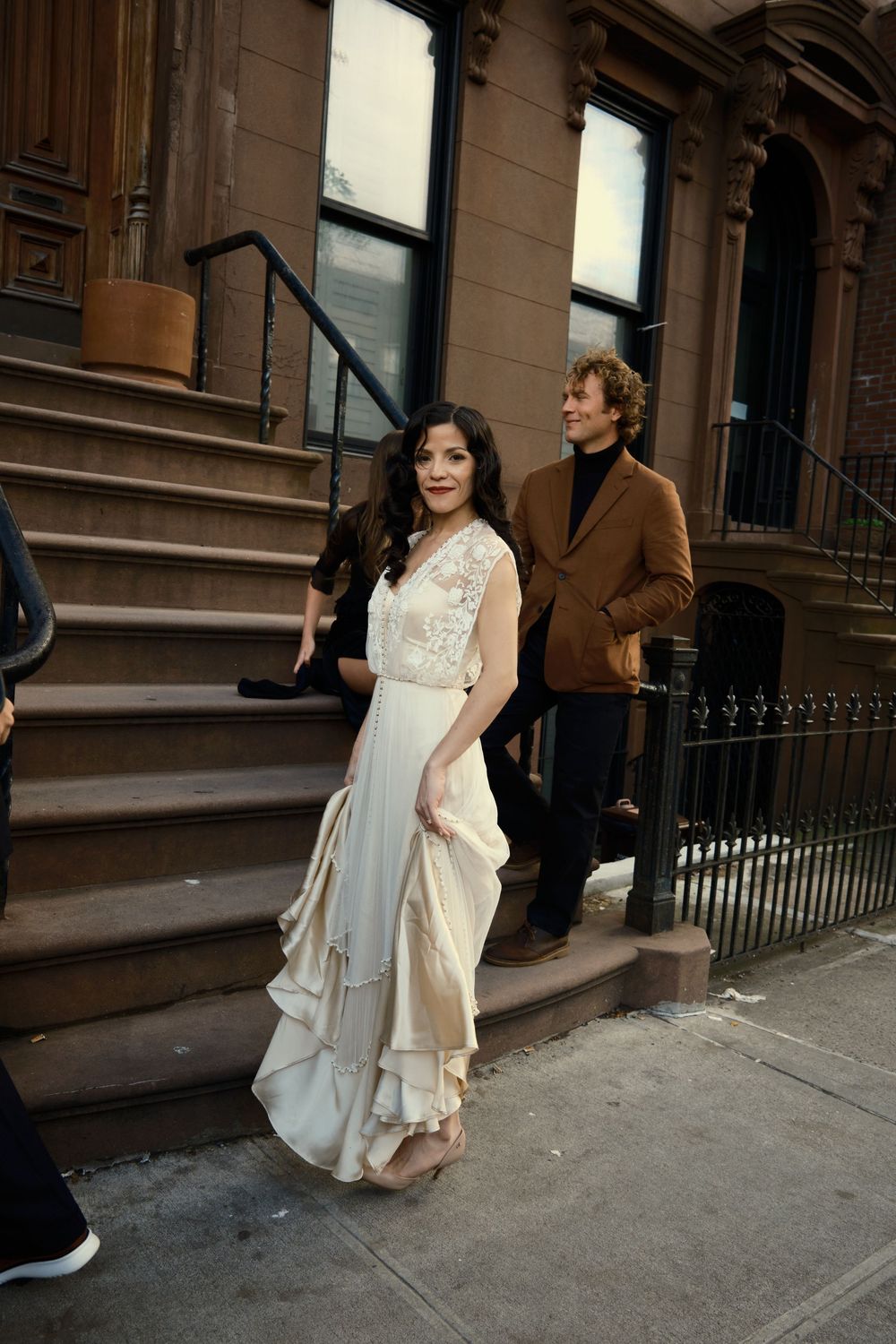 A vintage wedding dress on brownstone steps in an urban neighborhood setting at Mayson May
