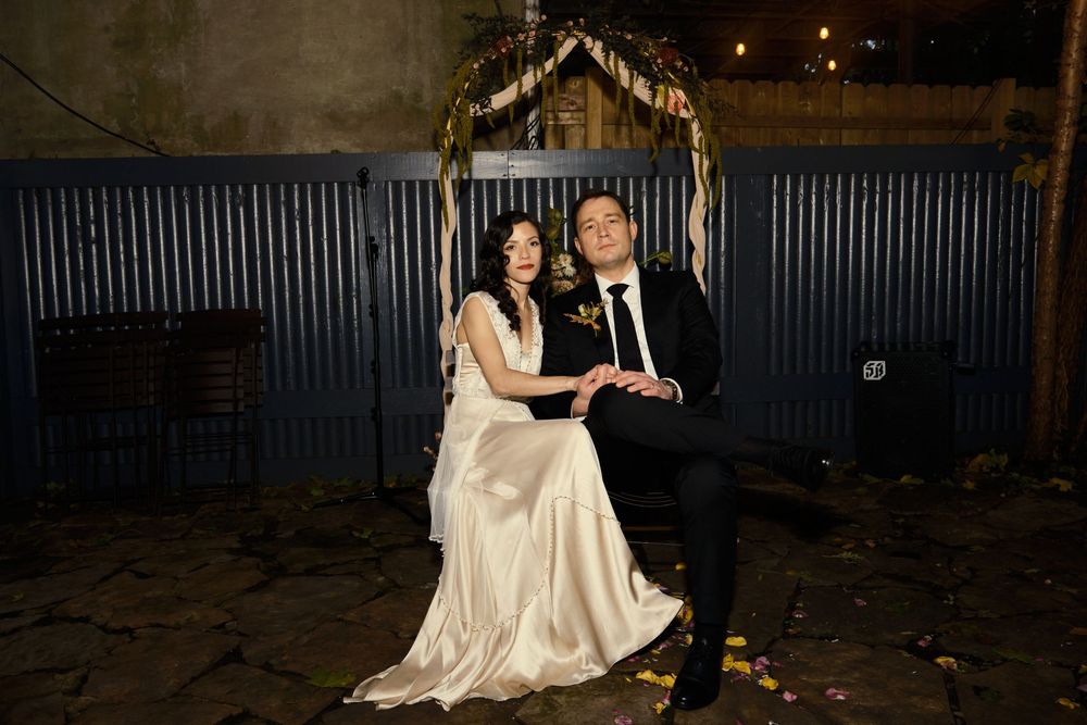 A romantic evening wedding moment captured under decorative lights and an arch at Mayson May