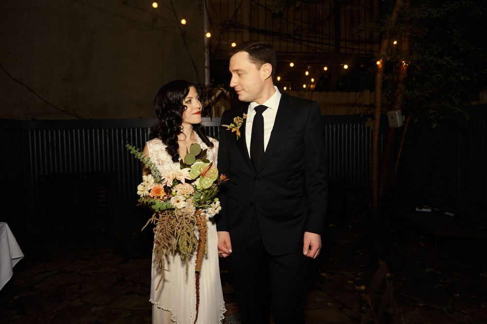 A couple gazes at each other lovingly during their nighttime outdoor wedding celebration at Mayson May